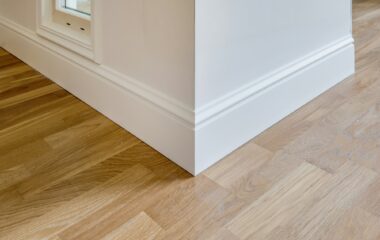 Detail of corner flooring with intricate crown molding and plinth.